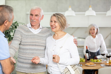 Two elderly couples meet for a holiday dinner at home. Greet each other