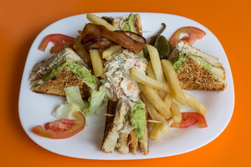 An appetizing chicken sandwich served with crispy fries and fresh side salad, representing classic comfort food that is beloved by many for casual dining occasions and gatherings.