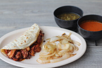 A tantalizing taco filled with freshly grilled meats and garnished with onions, served with...