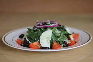 A delightful garden salad vibrantly showcasing an array of fresh vegetables, including tomatoes and cucumbers, highlighting the beauty of healthy eating and nourishment.