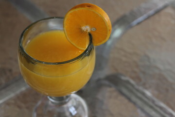A vibrant serving of fresh orange juice, beautifully garnished with an orange slice, highlighting the joy of refreshing beverages and the essence of lively mornings.