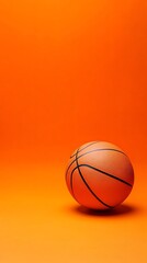 Fototapeta premium An orange basketball rests on an orange surface in a studio, illuminated by soft light. The focus is sharp on the ball