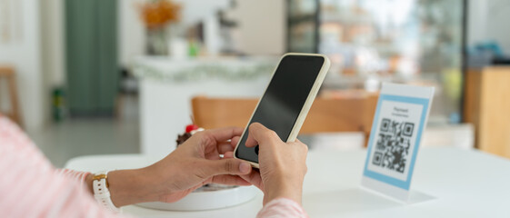 Woman use smartphone to scan QR code for order menu in cafe restaurant with a digital delivery. Choose menu and order accumulate discount. E wallet, technology, pay online, credit card, bank app.
