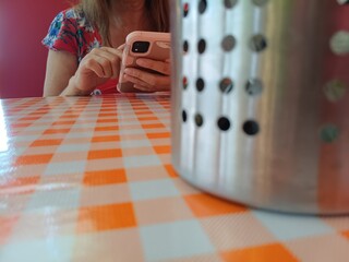 WOMAN IN A RESTAURANT LOOKING AT HER CELL PHONE IN A FLAT SEDUNDUM,


