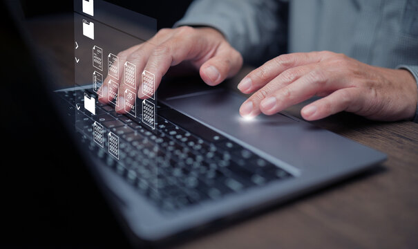 Document Management System concept. A man using DMS software on his laptop to store, share, track and manage files or documents.