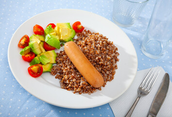 Boiled buckwheat with sausage, tomatoes and avocado