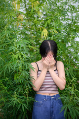 young woman enjoying herself and feeling happy among cannabis plants