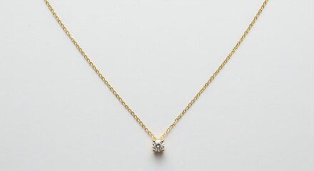 A gold necklace with a diamond pendant on a white background