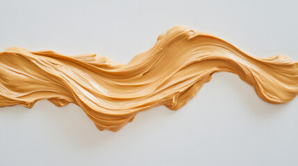 A creamy, appetizing wave of peanut butter presented against a plain white backdrop. 