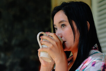 Woman enjoying a quiet moment, sipping beverage from a mug, a th