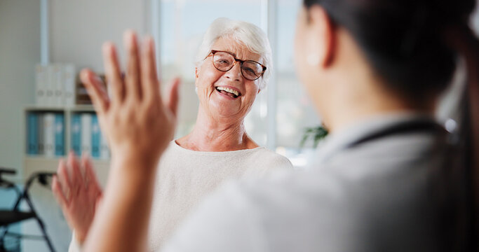 Senior patient, woman and high five in physio for rehabilitation success, good news or healing progress. Physical therapy, health worker and celebration in clinic for healthcare recovery or thank you