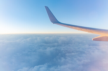 Obraz premium View from the airplane window at a beautiful cloudy sky and the airplane wing