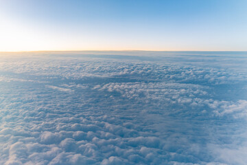 Beautiful orange and pink sunrise over the clouds, view from the plane.