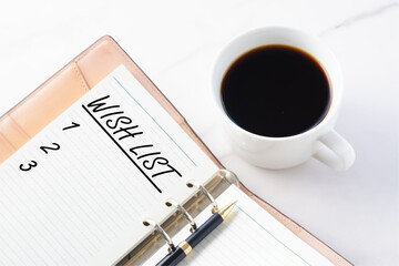 WISH LIST - Hand Written words WISH LIST and 1 2 3 on open notebook, organizer with cup of coffee and pen, life and business motivational inspirational concept
