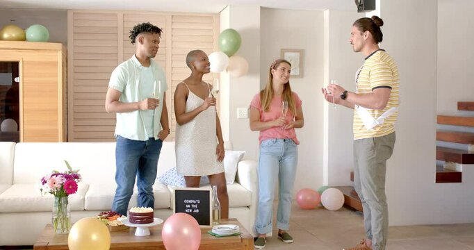 Friends celebrating new job with cake and champagne at home, smiling joyfully
