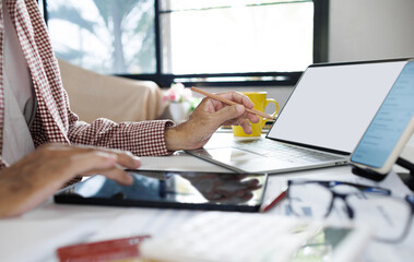 asian man working at home and meeting online with laptop holding pencil explain business plan via online meeting