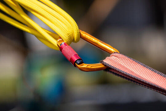 A yellow and orange rope is attached to a red and yellow piece of equipment