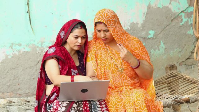 Rural indian women using laptop or learning computer together. Digital india. Wireless technology.