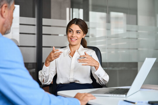 Female executive speaking to colleague working at office corporate meeting. Busy happy business woman professional bank manager lawyer attorney consulting client on finances management.