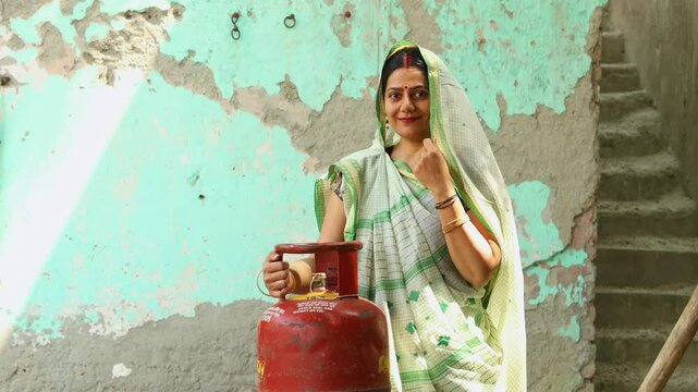 Indian woman with LPG Gas Cylinder for cooking in kitchen, Empowering Women. Clean energy. Rural India.
