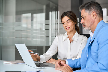 Mature business woman professional bank manager or financial advisor consulting client using...