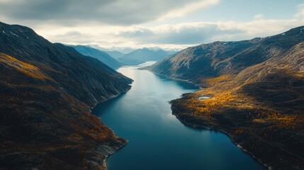 Aerial view of a diverse landscape featuring a winding river flowing through a mix of green and autumn-colored trees.