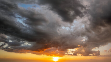 Beautiful sunset sky scenery. Bright colorful orange and yellow clouds on horizon