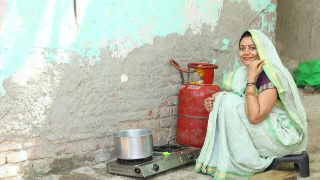 Rural Indian woman cooking in a traditional kitchen using an LPG gas cylinder, highlighting clean cooking fuel, daily life, and modern energy access in India 4k