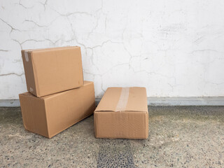 Stacked Cardboard Boxes Against a Cracked White Wall Background