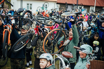 A joyful crowd lifts bicycles overhead in a spirited outdoor event, showcasing unity, energy, and a shared love for cycling and community action