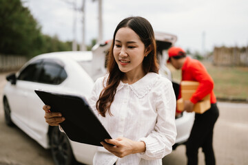 Obraz premium Uniformed delivery man receives merchandise from store to deliver to customer, delivers cardboard box to satisfied customer, completes delivery and signs for it.