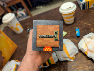 Naklejka premium France, 25 March 2025 : Minecraft themed merchandise alongside food and drinks on table.