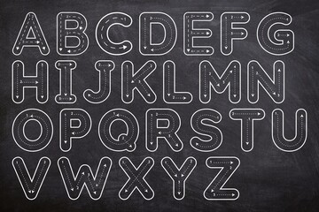 Font tracing collection. Uppercase letter tracing guide set on chalkboard. Font trace letter black and white isolated on black background