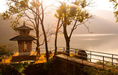 Obraz premium Rear view of tourist near lake at sunset