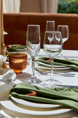 Table set with plates, glasses, napkins and candles.