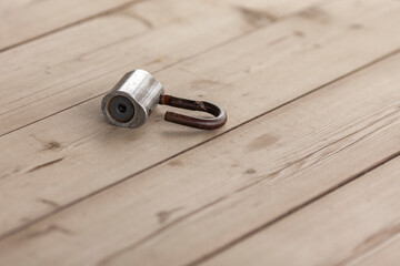 An old padlock lies on a wooden table