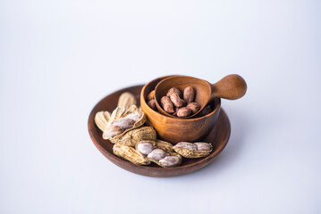Tiger Peanuts in  wooden bowls a collection of whole peanuts in their shells and a few without shells,healthy snacking concept with peanuts rich in protein and fats.