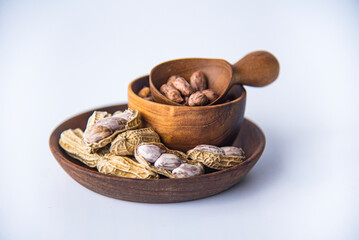 Tiger Peanuts in  wooden bowls a collection of whole peanuts in their shells and a few without shells,healthy snacking concept with peanuts rich in protein and fats.