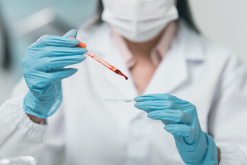 Medical research team conducting health and pharmaceutical experiments using blood samples in...