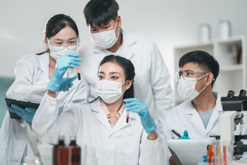 Medical research team conducting health and pharmaceutical experiments using blood samples in...