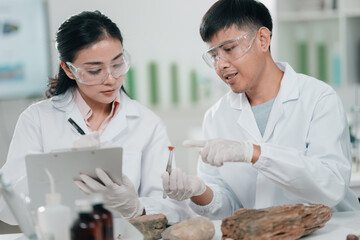 Geological researcher classifying rock and mineral samples in laboratory setting, focusing on earth...
