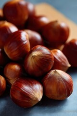 Obraz premium Fresh brown chestnuts on rustic table close-up