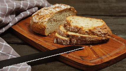 Sliced ​​fresh round bread on wooden table
