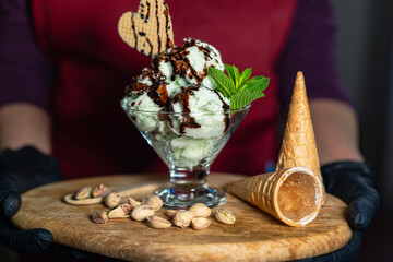 Handmade pistachio ice cream served with biscuit in a kitchen setting