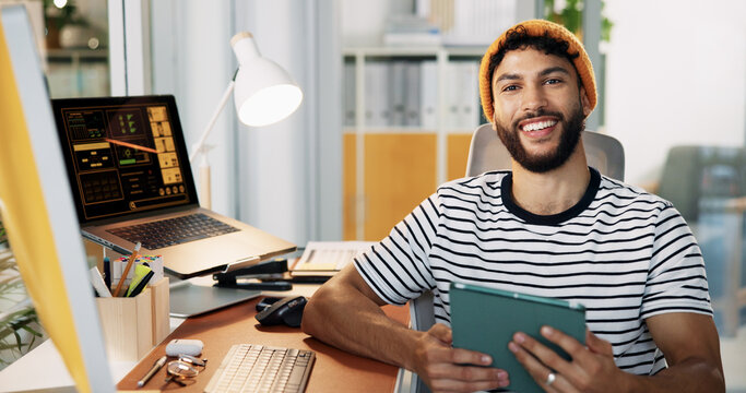 Creative, man and portrait with tablet in office for social media insights, campaign performance and data analysis. Marketing professional, employee and happy with digital app for engagement metrics