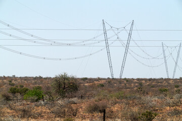Endlos lange Stromleitungen durch Steppen und Wüsten in Namibia