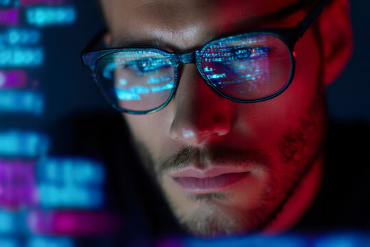 Focused programmer analyzes complex code in a dark tech environment at night