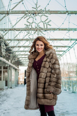 Beautiful brunette woman wearing fur winter coat