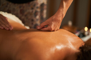 Naklejka premium Masseur giving back massage to client in spa center