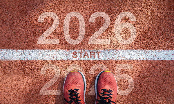 New year 2026 concept, beginning of success. Text 2026 written on asphalt road and male runner preparing for the new year. Concept of challenge or career path and change.